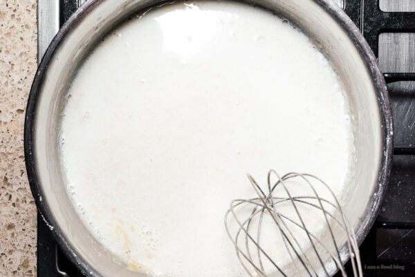 combining milk and roux to make a bechemel | www.iamafoodblog.com
